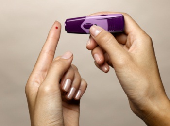 Woman using diabetes test kit